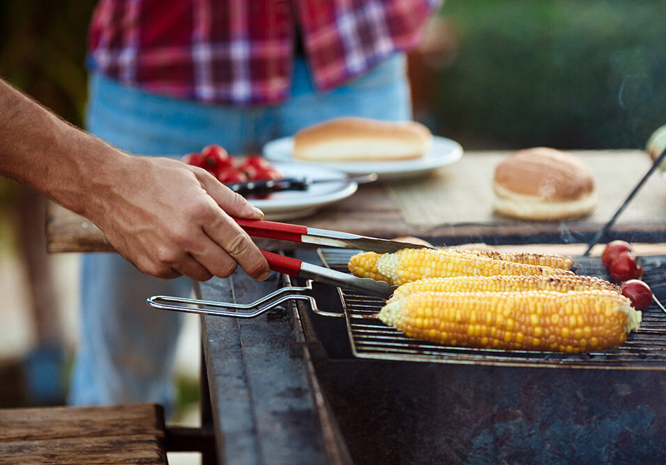 young-men-roasting-barbecue-grill-cottage-countryside